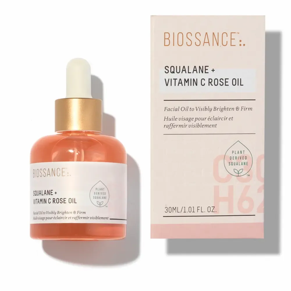 A 30 ml dropper bottle of Biossance Squalane plus Vitamin C Rose Oil, the oil pale orange, beside its box.